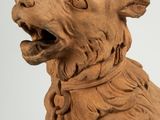 a clay sculpture of a dog with its mouth open