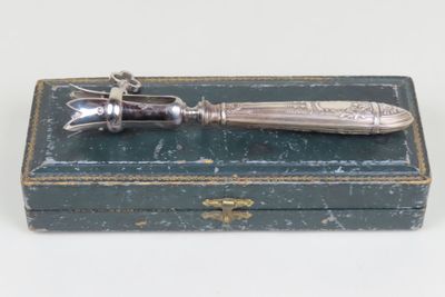 an antique silver plated knife sitting on top of a green box