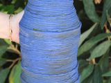 a person holding a blue vase in their hand