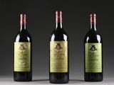 three bottles of wine are lined up on a table