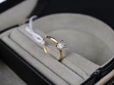 une bague dans une boîte, attachée à un cordon blanc