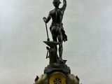 a statue of a man holding a sword and a clock