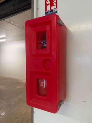a red fire extinguisor on the wall of a building