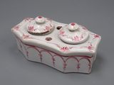 une boîte blanche et rose avec un couvercle, posée sur une surface grise