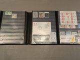 three folders with stamps and envelopes are lined up on a table