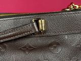 a close up of a brown louis vuitton bag on a pink background
