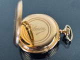 a close up of a pocket watch on a table