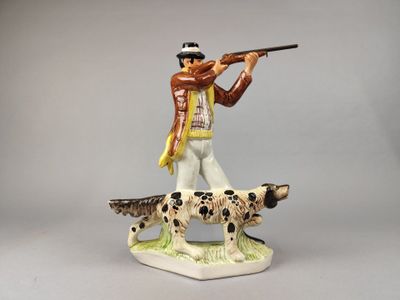 une figurine représentant un homme armé d'un pistolet et accompagné d'un chien