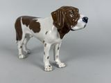 a figurine of a brown and white dog on a gray background