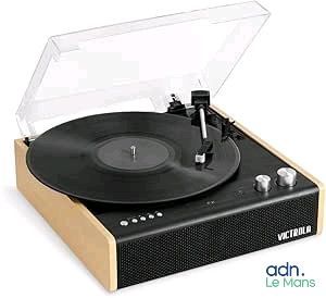 une platine vinyle recouverte d'un couvercle transparent, posée sur une surface blanche