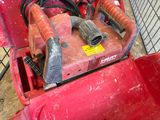 a red machine that is sitting on the ground