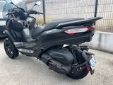 a black scooter parked on the side of the road