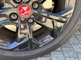 a close up of a car wheel with a red emblem on it