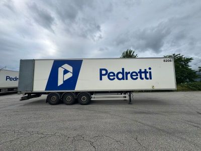 the trailer is parked in a parking lot with a cloudy sky in the background