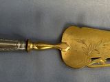 a close up of a gold shovel on a white cloth