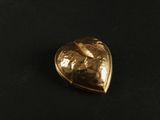 a close up of a gold heart shaped object on a black surface
