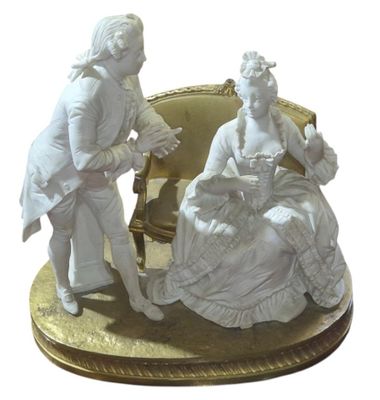 une figurine représentant un homme et une femme assis sur une chaise