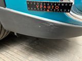 a close up of a blue car with a ruler on it ' s bumper