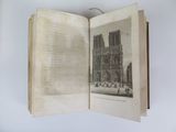an open book with a drawing of a cathedral in the background