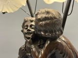 a statue of a woman holding a child under an umbrella