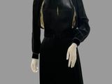 an image of a mannequin wearing a black dress with gold trim