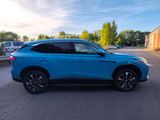 a blue suv parked in a parking lot next to a building
