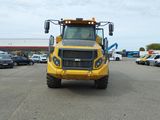 un gros camion jaune garé sur un parking