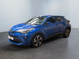 un SUV Toyota C-HR bleu garé dans une pièce blanche