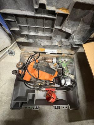 une boîte à outils contenant des outils, posée sur le sol