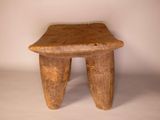 a small wooden stool that is sitting on a white surface