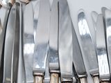 a lot of knives and spoons on the table