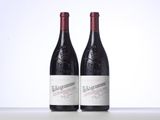 two bottles of red wine sitting on top of a table