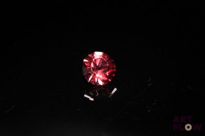 a red diamond in the dark with a black background