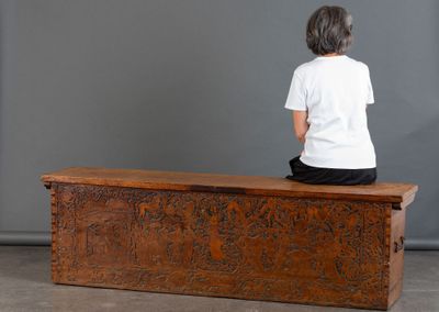 une femme assise sur un banc en bois