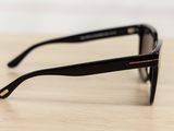 sunglasses on a wooden table with a white wall in the background