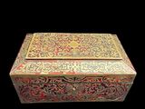 a gold and red box sitting on a black surface