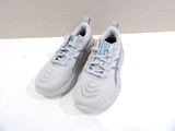 une paire de baskets blanches avec des lacets bleus, posée sur une surface blanche
