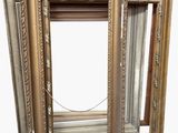deux cadres dorés posés l'un à côté de l'autre sur une surface blanche
