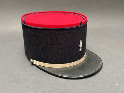 chapeau haut-de-forme noir et rouge orné d'une bande dorée sur fond gris