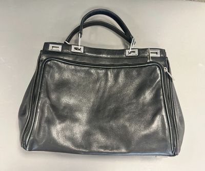 black leather handbag with metal handles on a white surface