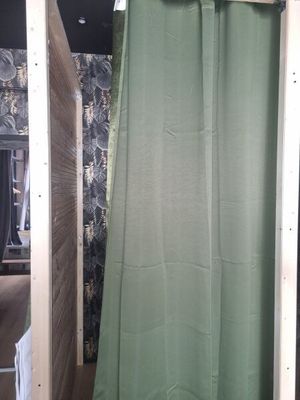 a green shower curtain hanging in a bathroom next to a toilet