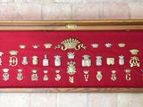 a red display case with a lot of gold and silver items in it