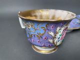 pair of porcelain cups and saucers with floral designs on them
