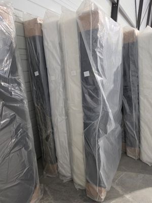 de nombreux matelas emballés dans des sacs en plastique dans un entrepôt
