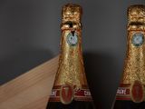 two bottles of champagne sitting on a wooden table