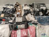 une grosse pile de vêtements posée sur une étagère