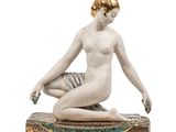 statue représentant une femme assise sur un coussin, une fleur à la main