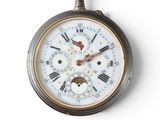 a close up of a pocket watch on a white surface