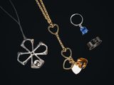 trois colliers différents et une bague sur fond noir