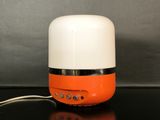 an orange and white speaker sitting on top of a black table